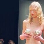 Модель прикрыла голую грудь посудой на показе